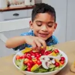 Enfant devant un assiette de légumes